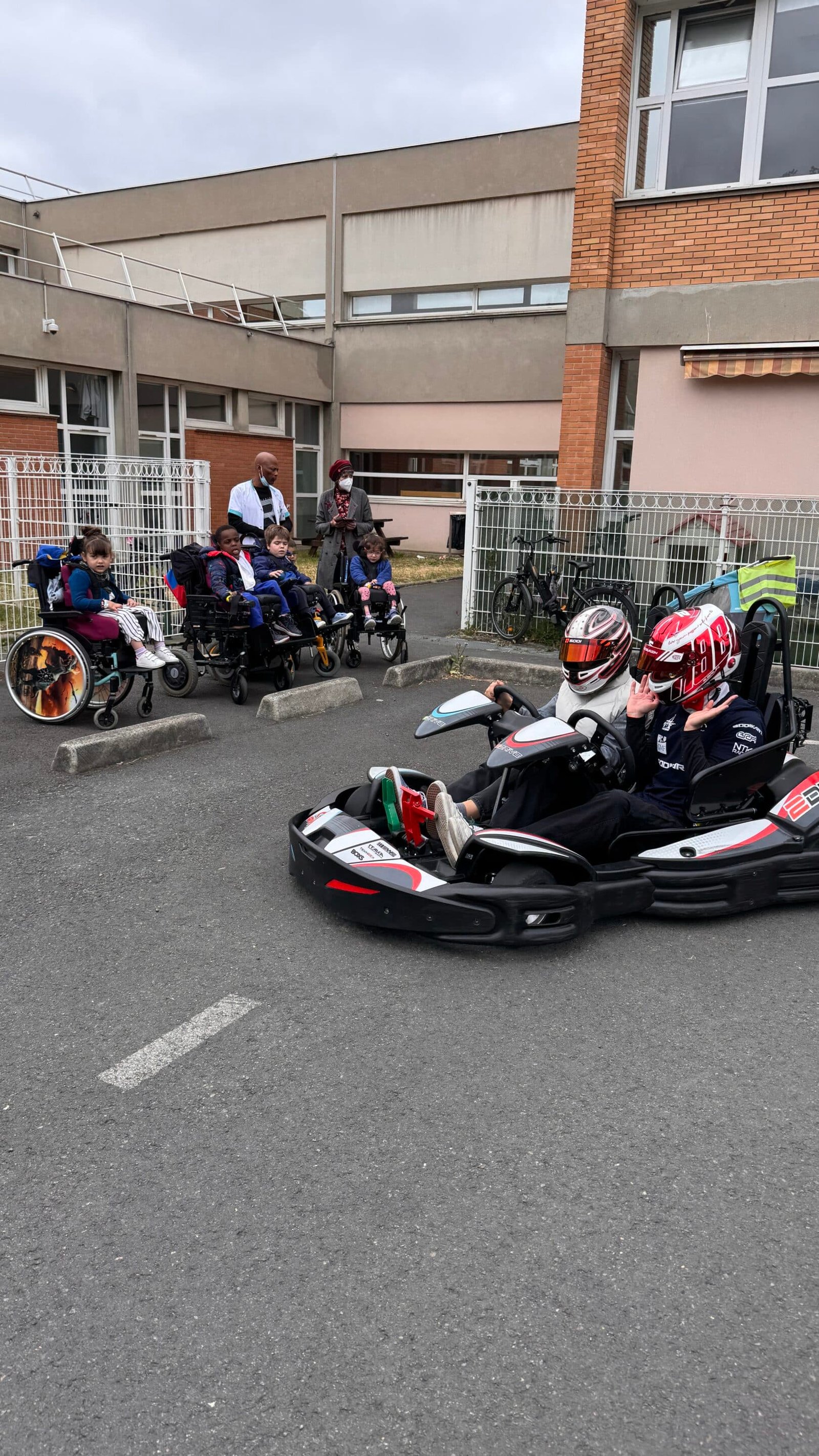 Enfants en fauteuils roulants regardant karting.