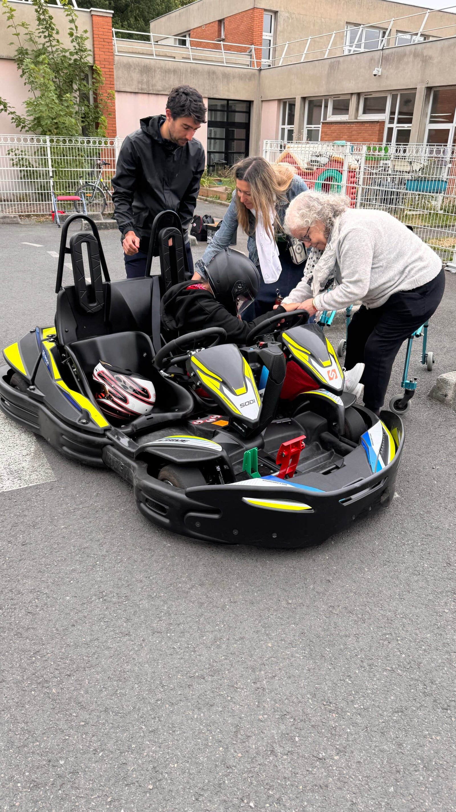 Personnes aident quelqu'un à monter dans un kart.