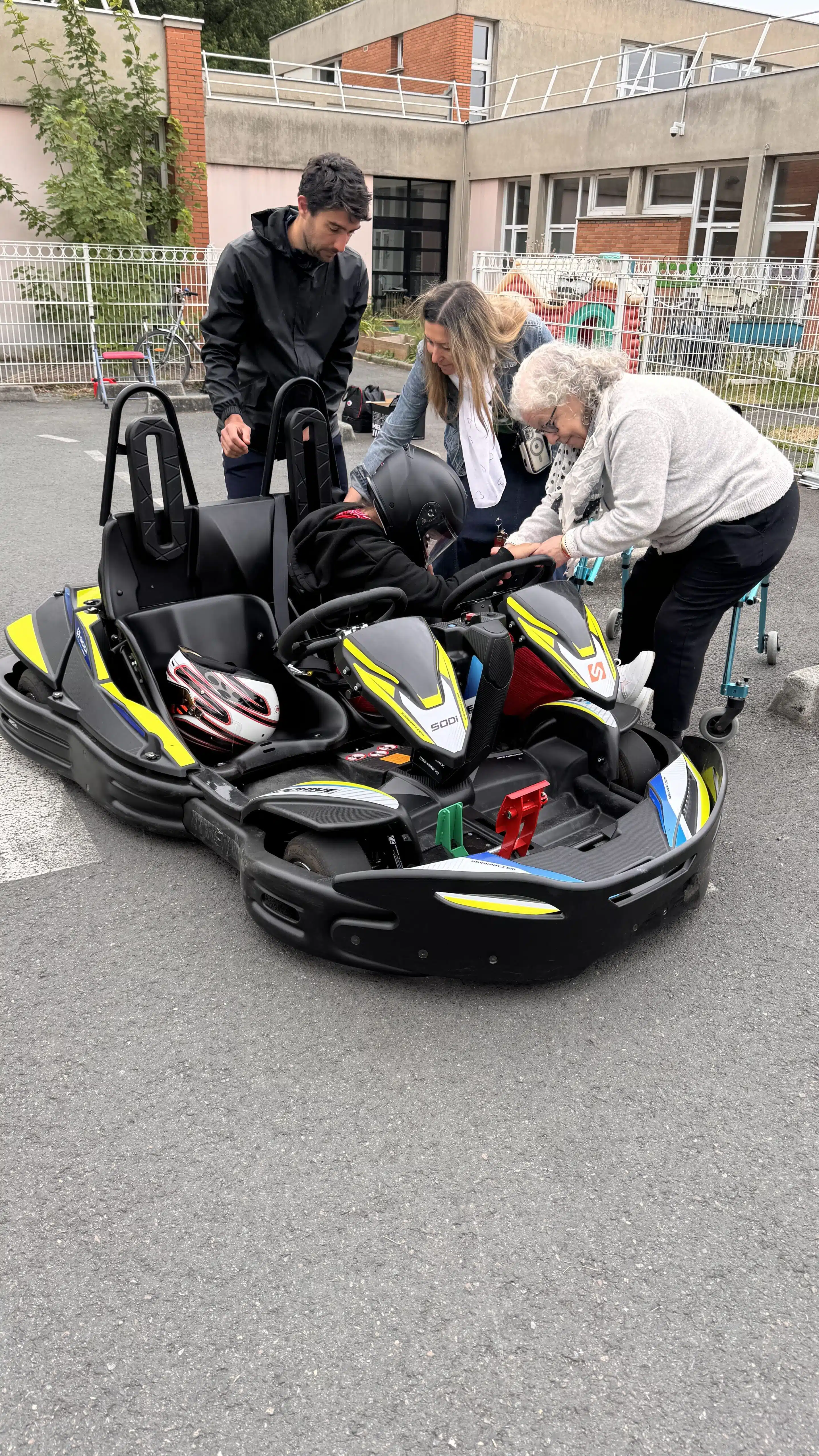 Personnes aident quelqu'un à monter dans un kart.
